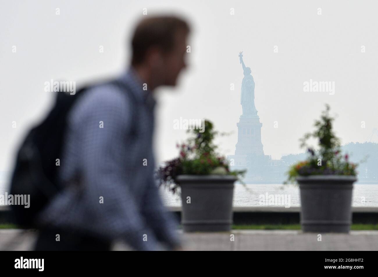 New York, USA. 20th July, 2021. The Statue of Liberty, seen from Manhattan's Battery Park, is veiled in a thick haze, created by smoke originating from the West Coast wildfires, New York, NY July 20, 2021. Massive blazes continue to burn in the state of Oregon and California. (Photo by Anthony Behar/Sipa USA) Credit: Sipa USA/Alamy Live News Stock Photo