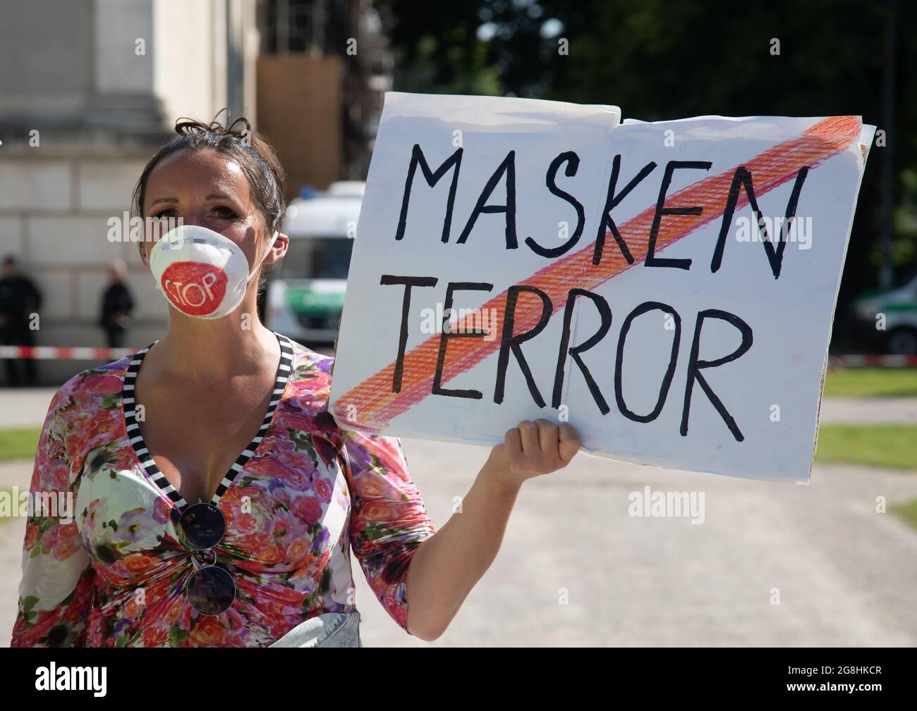 Demonstrantin mit Stop auf ihrer Maske und Schild:  Masken Terror