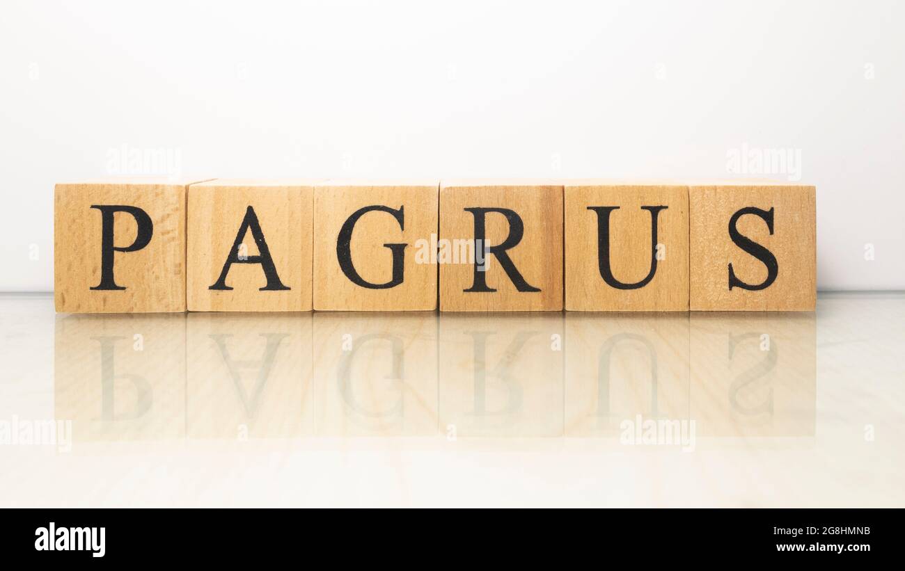 The word Pagrus was created from wooden letter cubes. Seafood and food. close up. Stock Photo