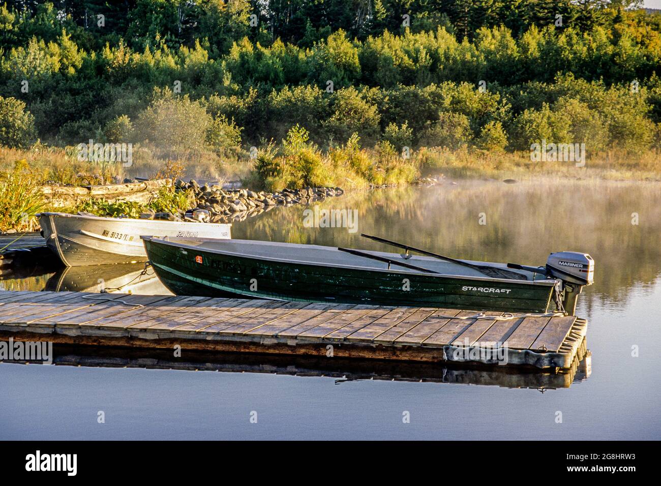 A couple of motor boats at a dock on Second Roach pond in the Moosehead Lake Region of maine Stock Photo