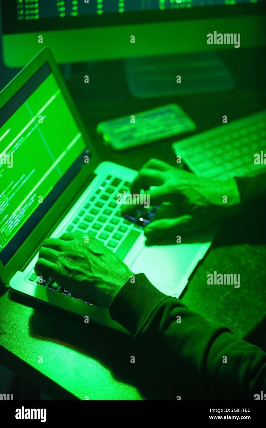 Hacker using computer in dark room Stock Photo - Alamy