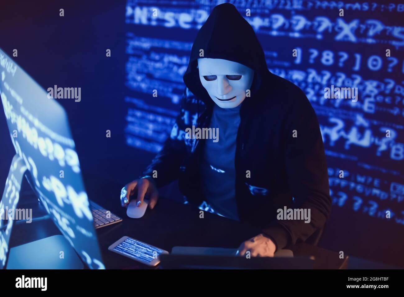 Hacker using computers in dark room Stock Photo