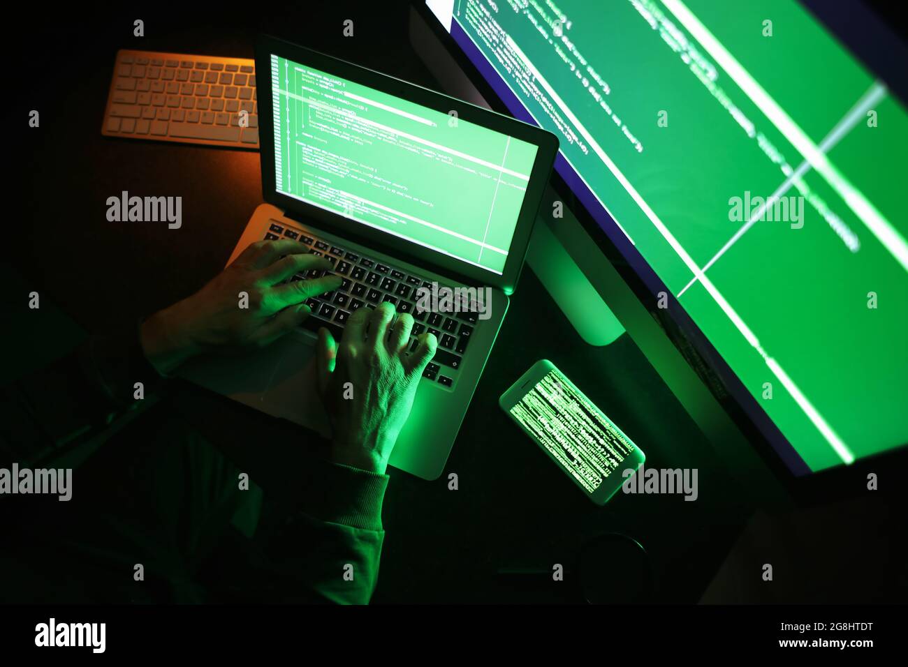 Hacker using computer in dark room Stock Photo - Alamy