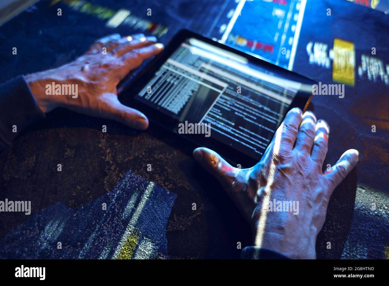 Hands of hacker with tablet computer on dark background Stock Photo