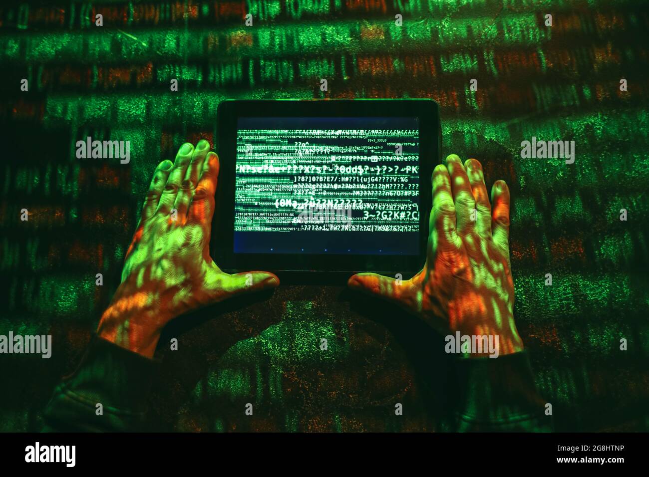 Hands of hacker with tablet computer on dark background Stock Photo
