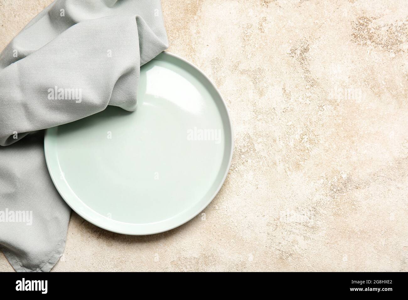 Fabric napkin and plate on light background Stock Photo - Alamy