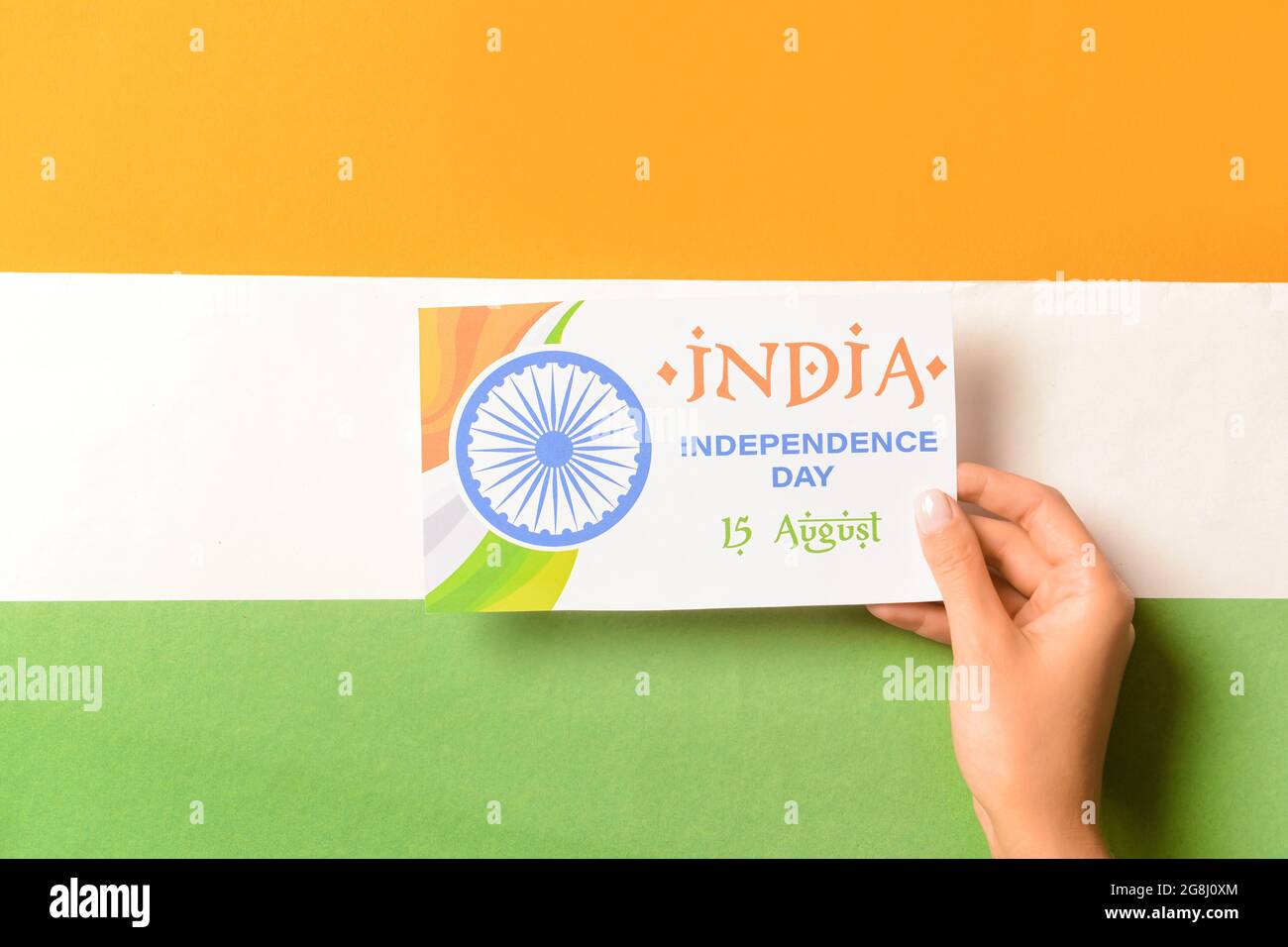 Hand with greeting card for Independence Day against Indian flag Stock ...