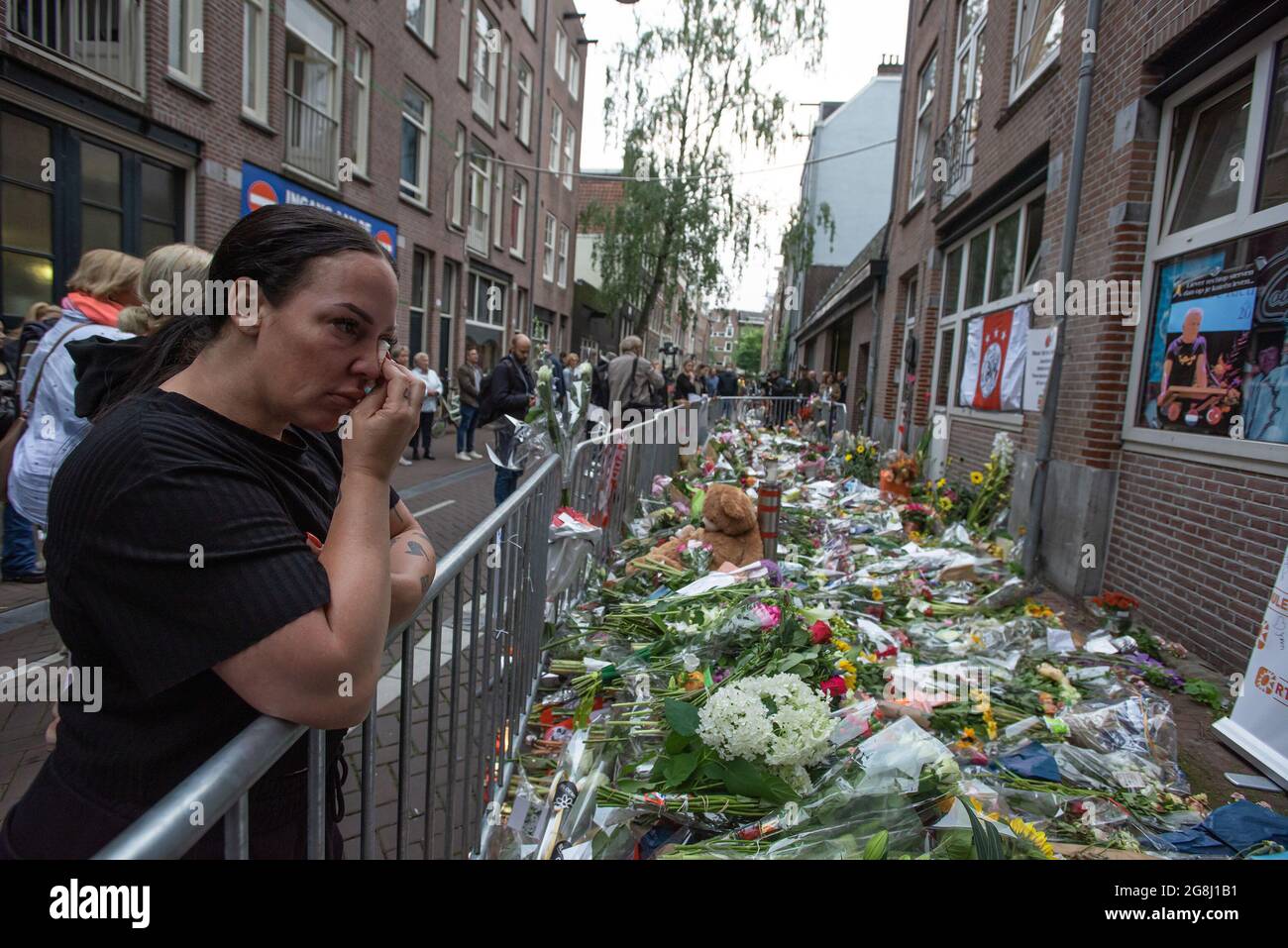 Amsterdam, Netherlands. 15th July, 2021. Sightseer's and well-wishers gather to pay their last respect to slain Dutch investigative journalist Peter R. de Vries.Dutch Crime investigative reporter Peter de Vries, 64 was pronounced dead this afternoon after lasts Tuesday 6 July near fatal shooting at around 19:30 on Leidsedwarsstraat in Amsterdam. The reporter had always declined the protection of bodyguards. A statement from his relative had read: ''Peter has lived by his conviction: 'On bended knee is no way to be free'.'' Peter de Vries, had won critical acclaim for his reporting on the Du Stock Photo