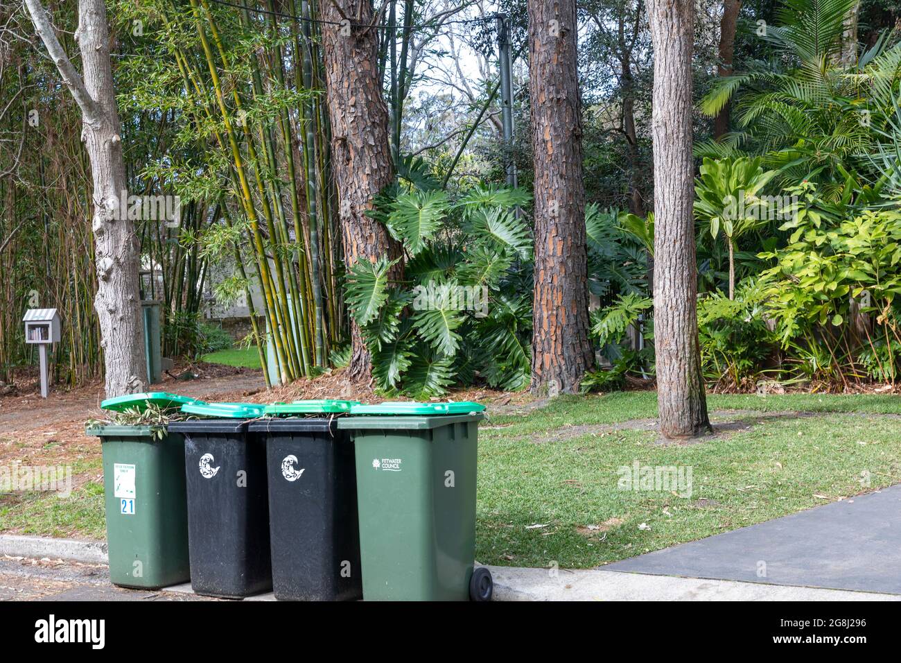 Green vegetation recycling bins on a Sydney street awaiting council collection by refuse truck,Australia Stock Photo