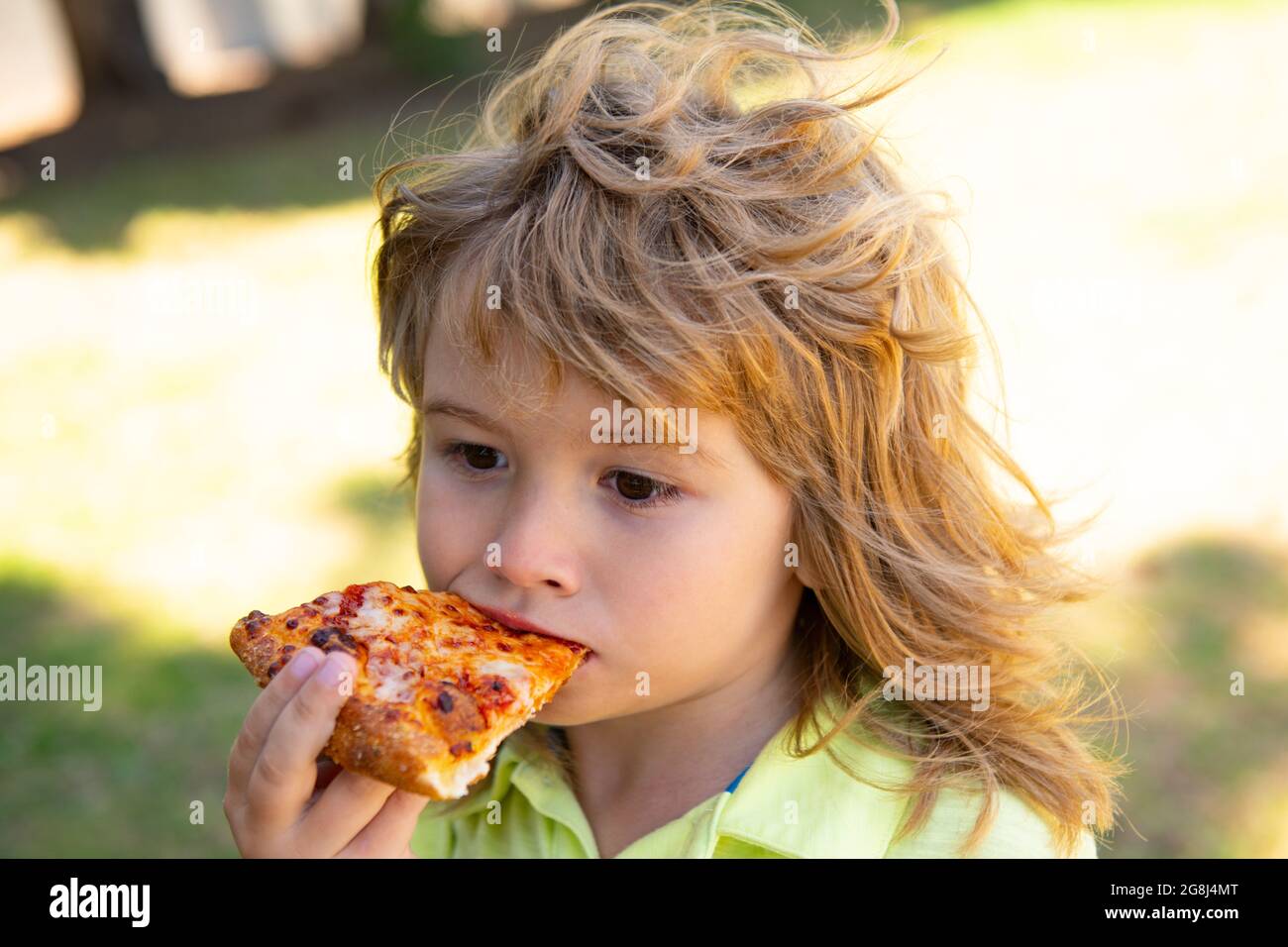 Kid boy eating pizza outdoor. Pizza the best food. Cute little child