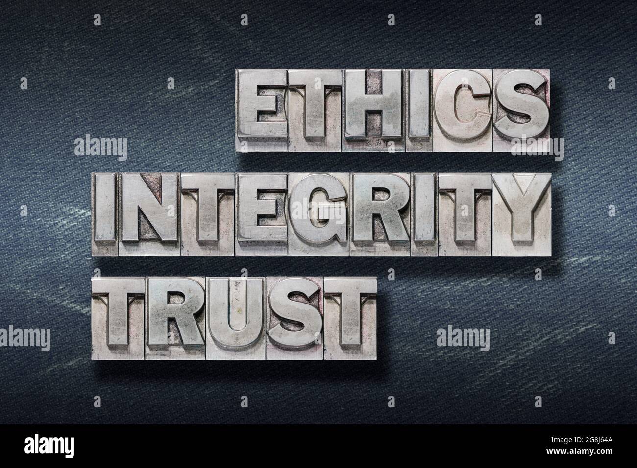 ethics, integrity, trust words made from metallic letterpress on dark jeans background Stock Photo
