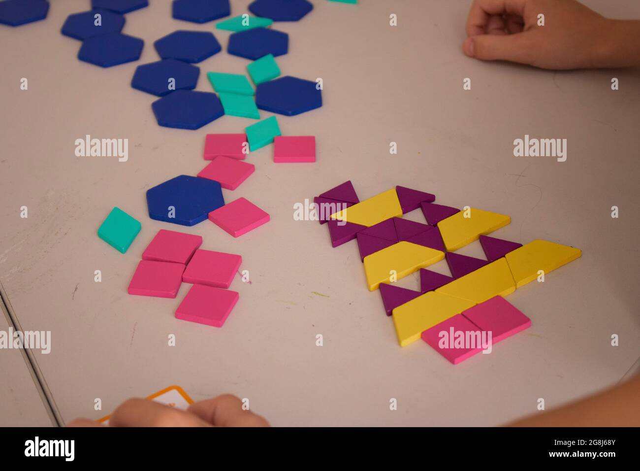 Colorful plastic bricks on table with kids hands Stock Photo