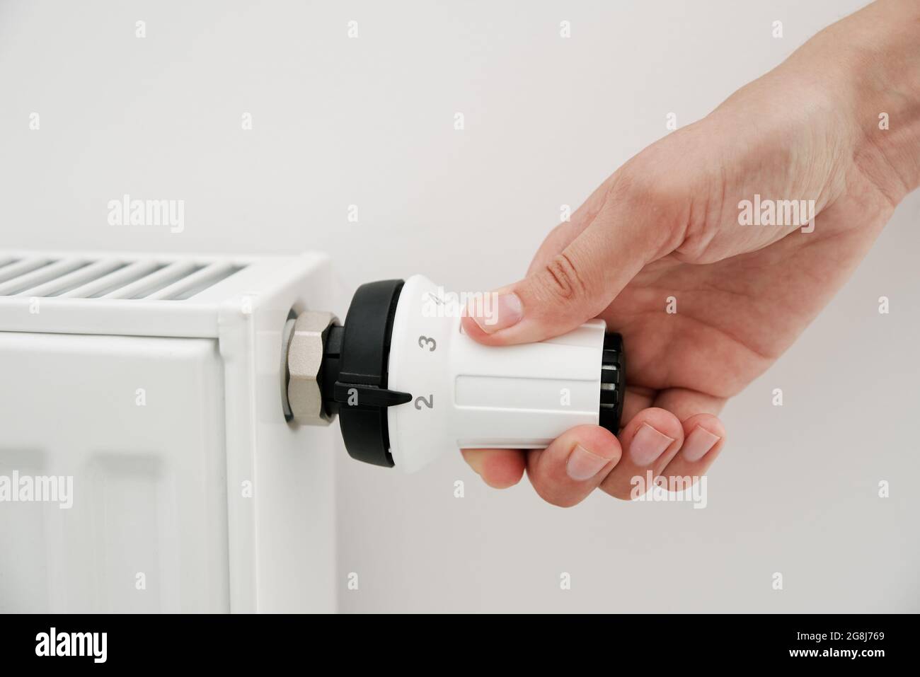 Heat radiator knob. Woman hand adjusting temperature on heating