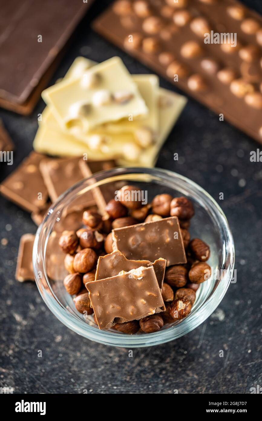 Chocolate bar with hazelnuts on black table. Stock Photo
