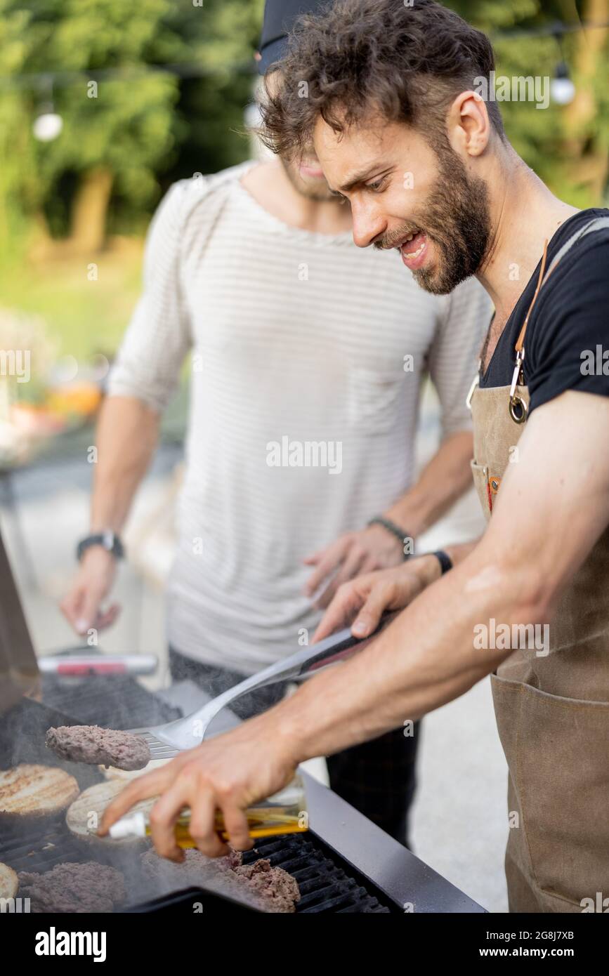 Two guys grilling at backyard Stock Photo