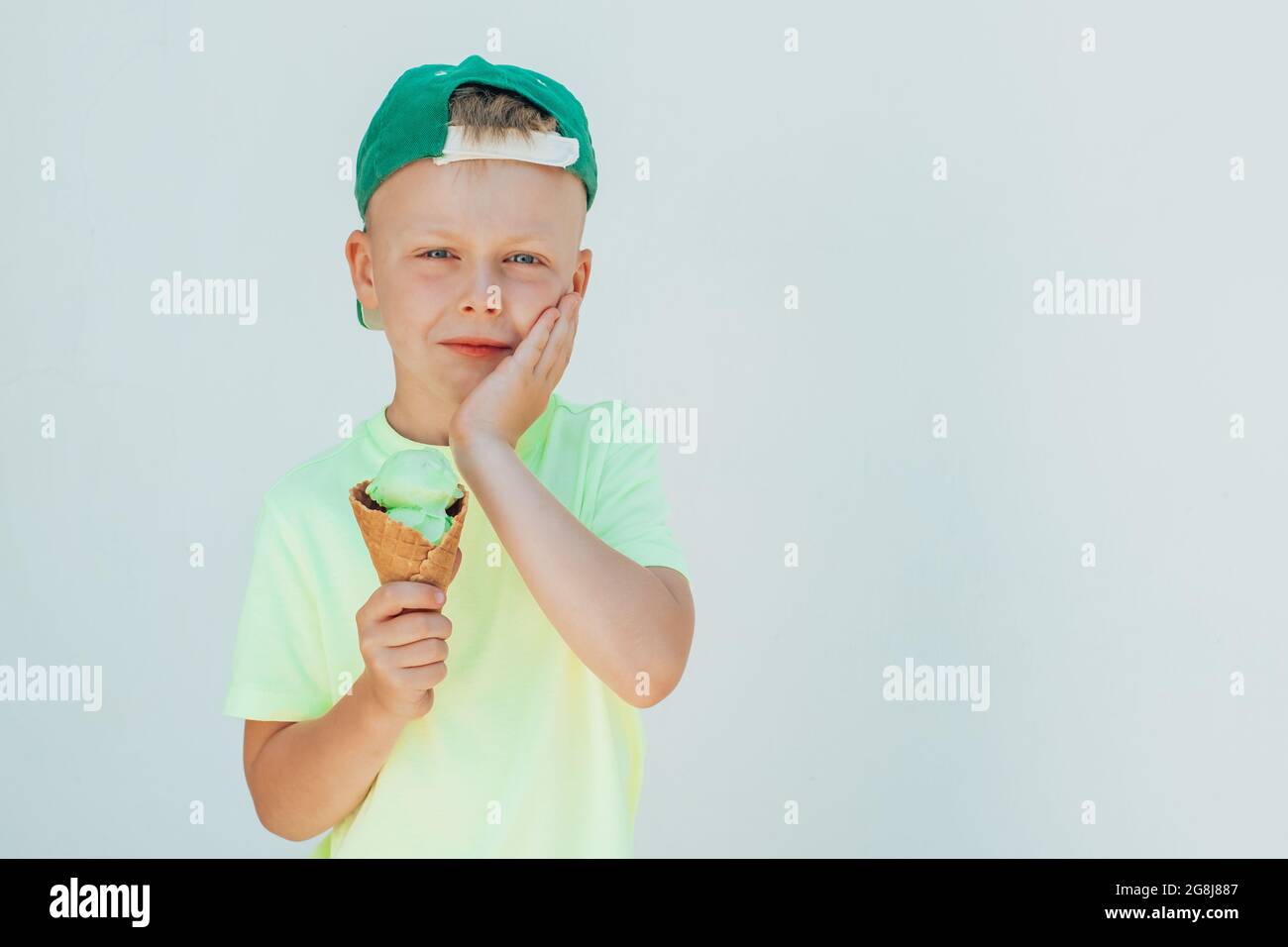 Portrait of a boy eating ice cream and felt toothache. dental care