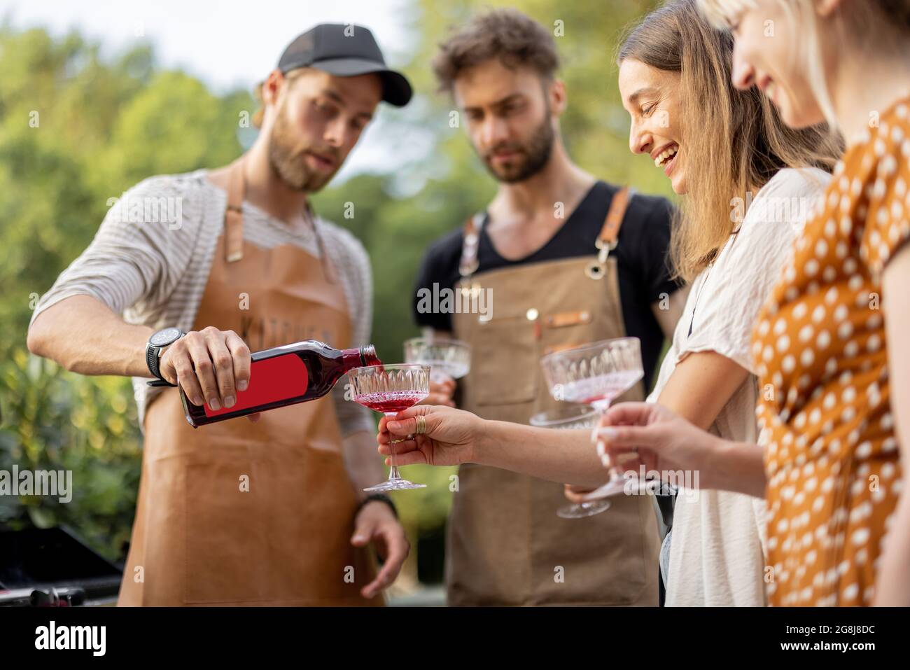 Friends pouring alcohol at picnic Stock Photo Alamy