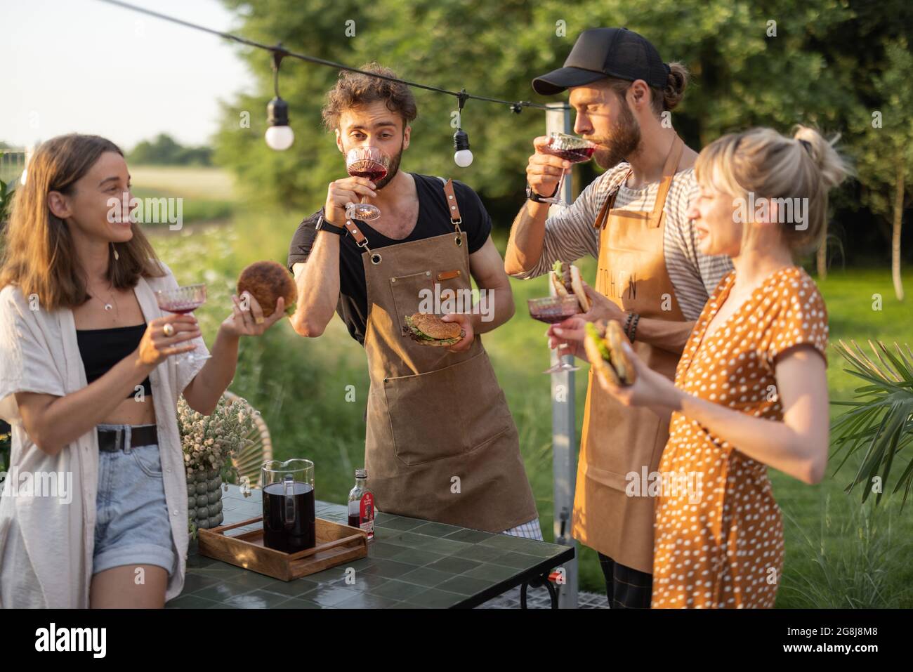 Young friends with drinks at backyard Stock Photo