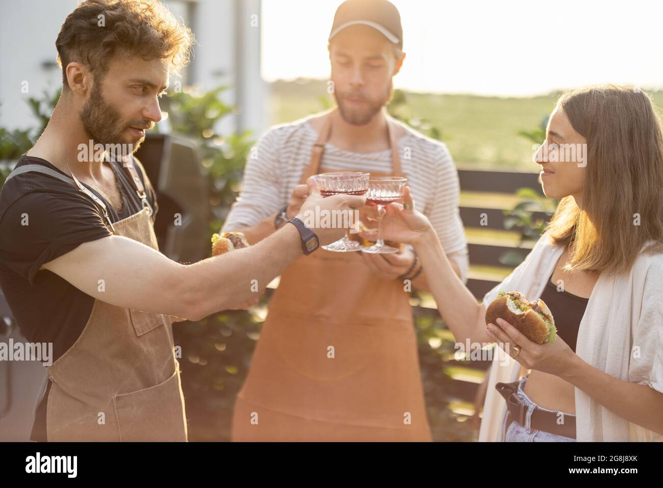 Friends celebrating with alcohol drinks outdoors Stock Photo