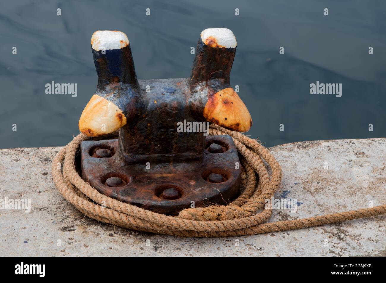 Dock mooring cleat and rope located at a small coastal harbour Stock Photo