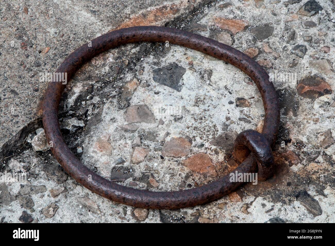 Old rusting steel mooring ring at a coastal harbour location Stock Photo