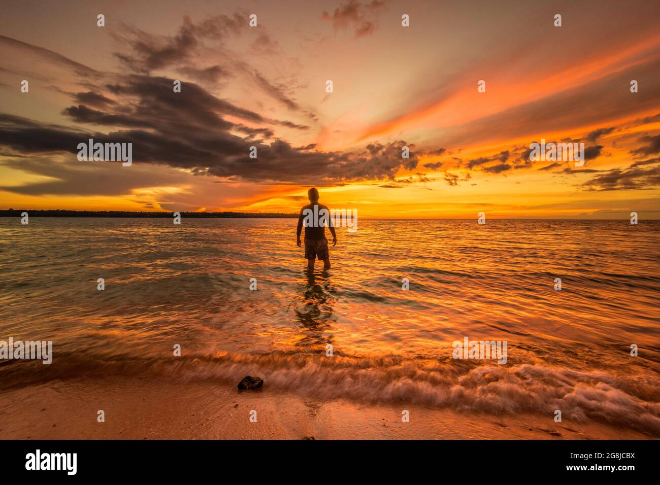 Silhouette of a man standing on the shore at a beautiful sunset Stock ...