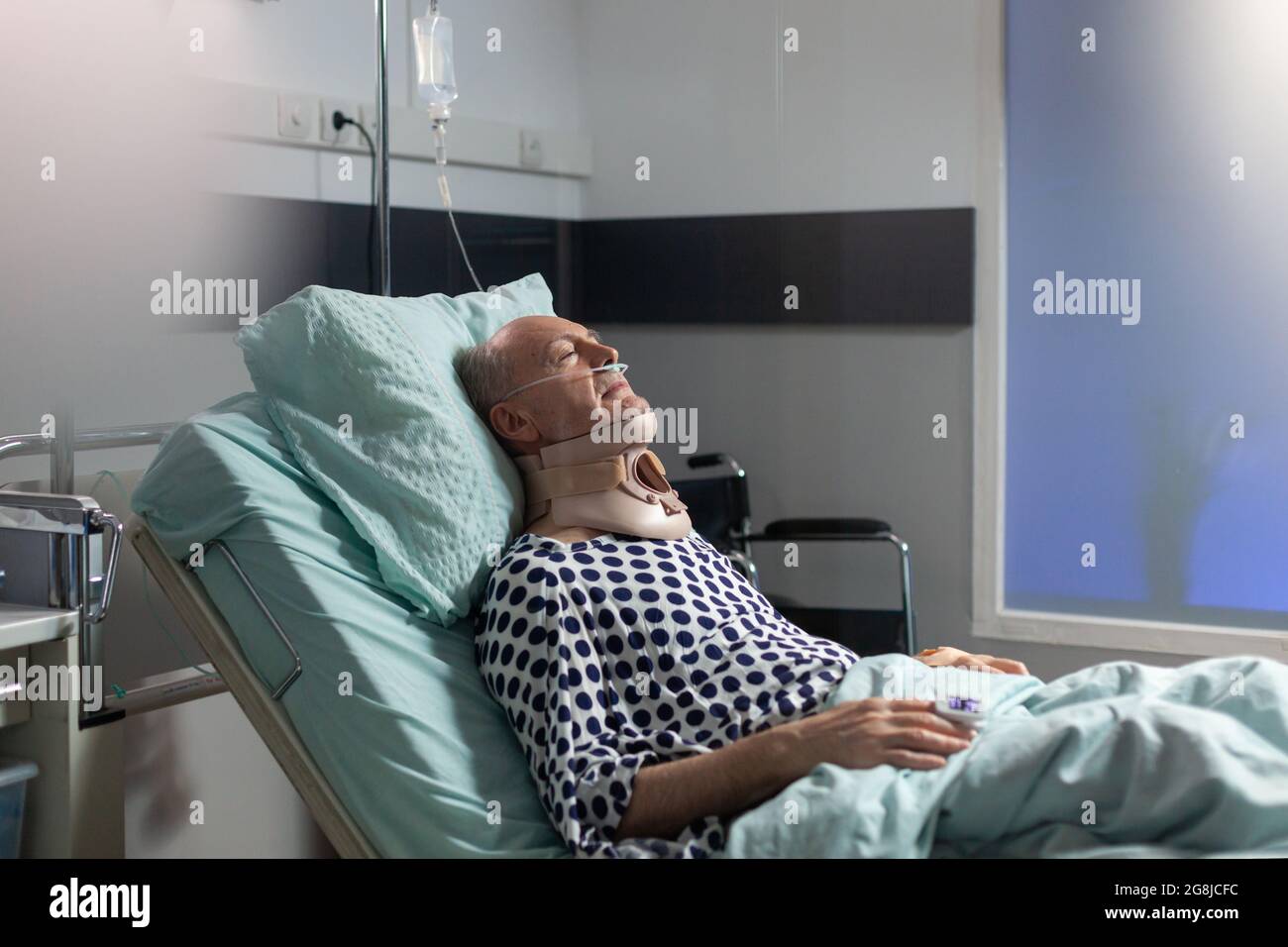 Senior man suffering after serious accident laying in hospital bed