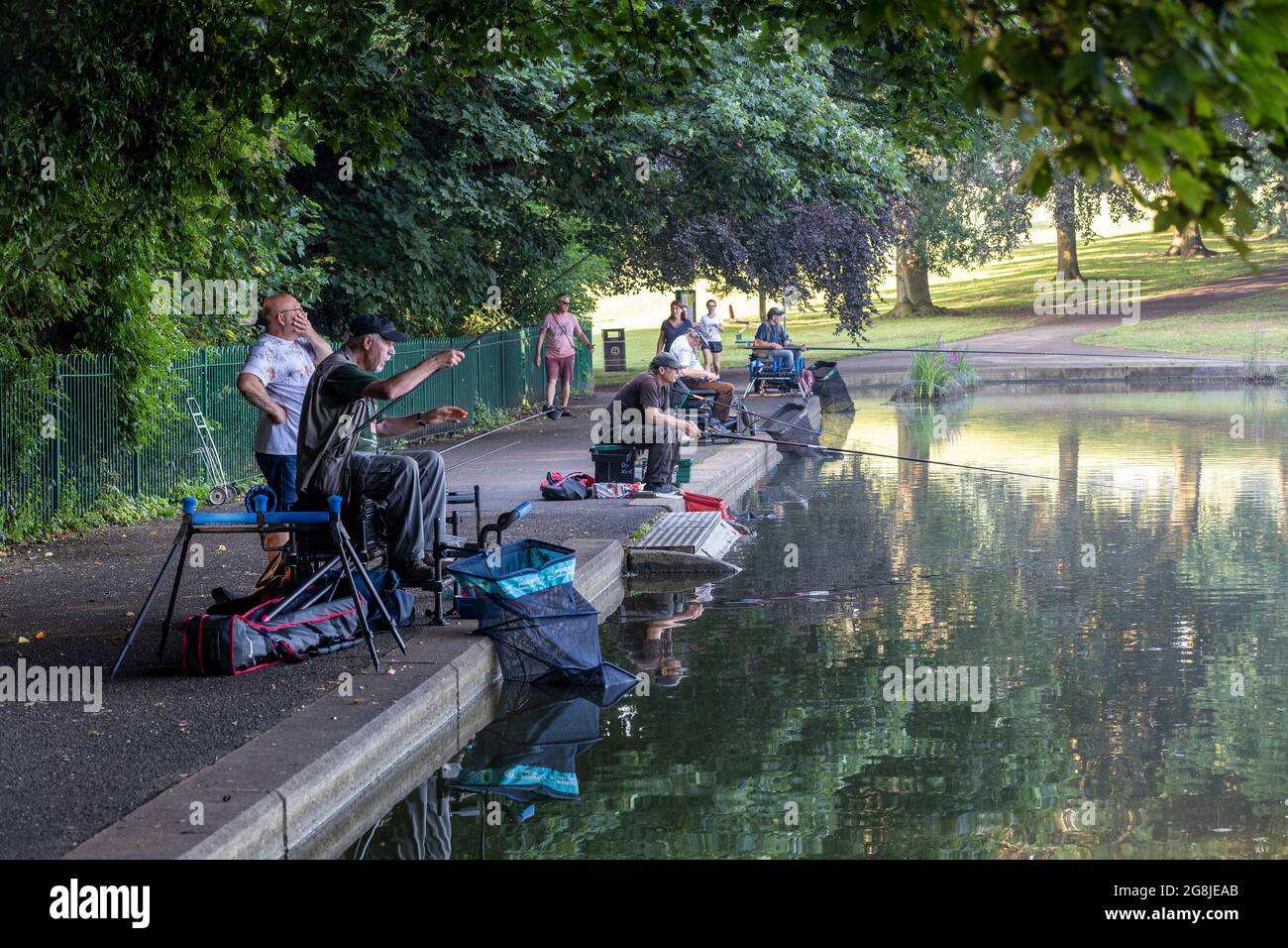Northampton, UK. Weather, 21st July 202. Fishermen in the shade early morning in Abington Park, it’s going to be very humid after last nights thunder and rain. Credit: Keith J Smith./Alamy Live News Stock Photo