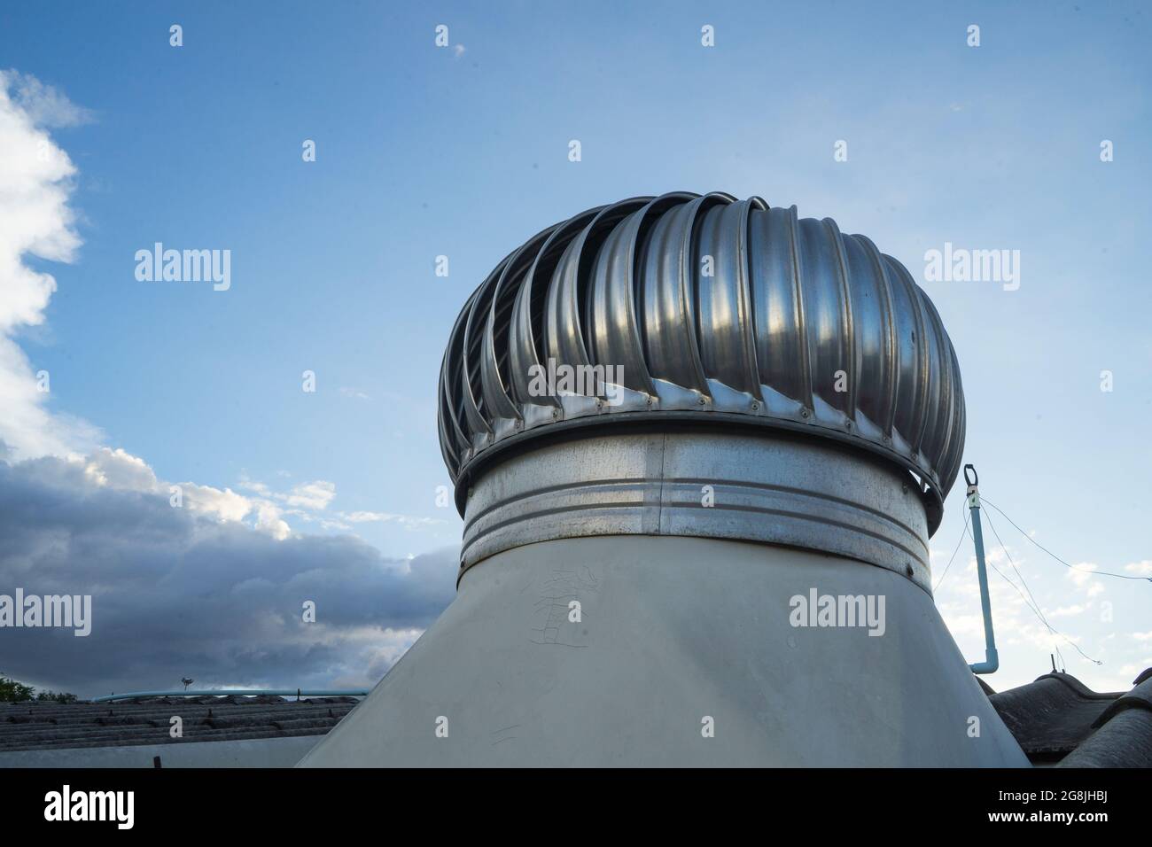 Cloud Blue sky and Roof Ventilator on roof of industryfor cooling in a natural way by relying on natural winds, selective focus and Low angle shot Stock Photo