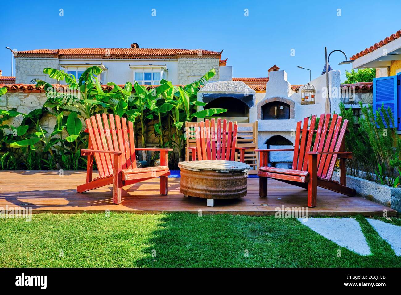 Three rustic wooden chairs, vintage coffee table and stone oven at the