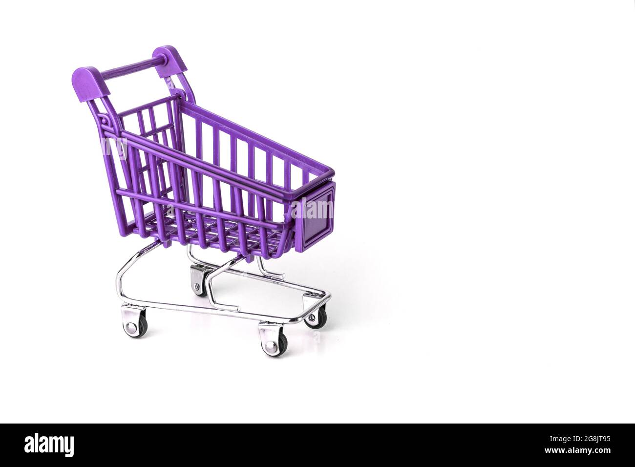 Close up of supermarket grocery push cart for shopping with black wheels and plastic elements on handle isolated on white background. Concept of Stock Photo