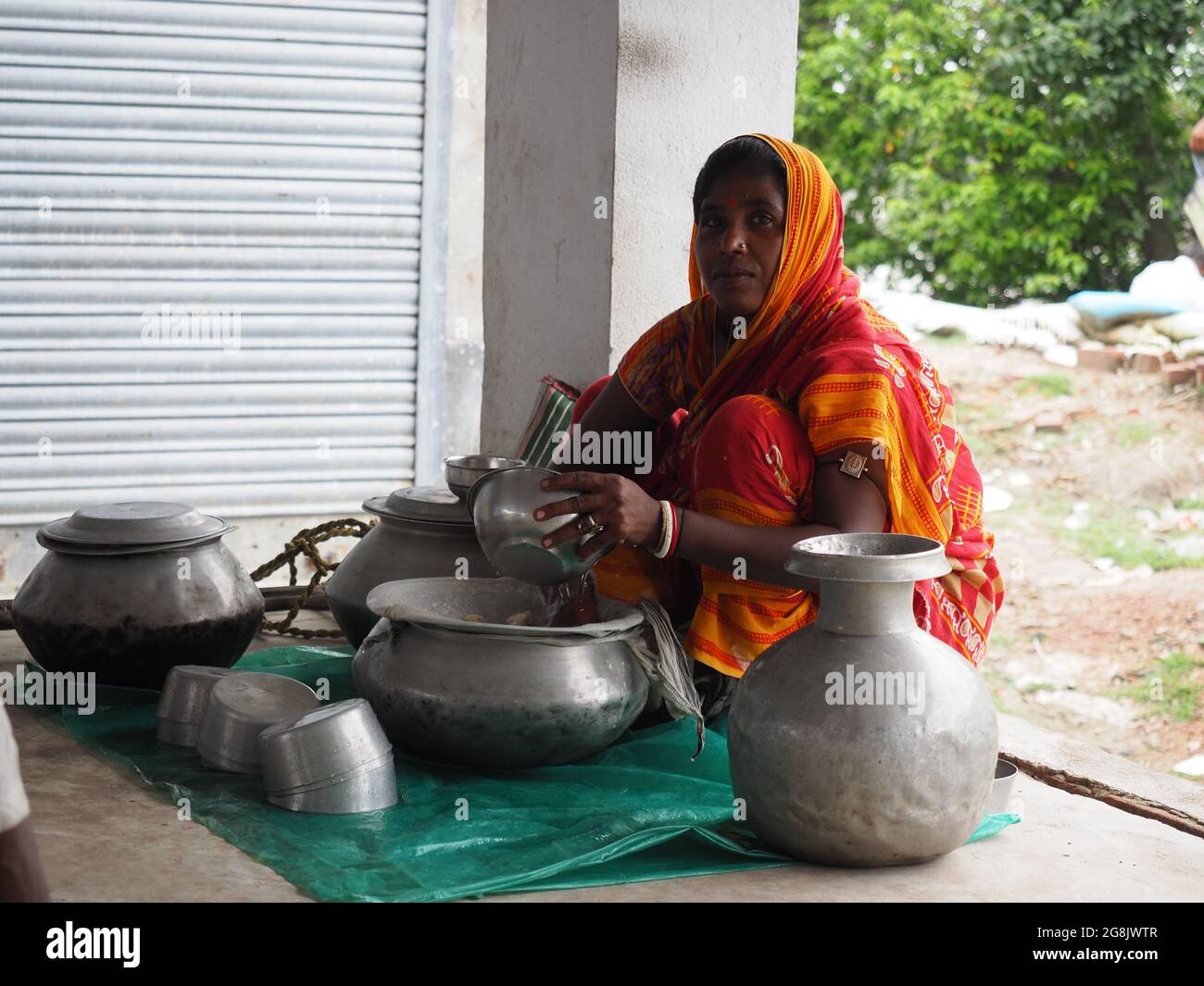 Washing a Large Cooking Pot in an Ashram (India)