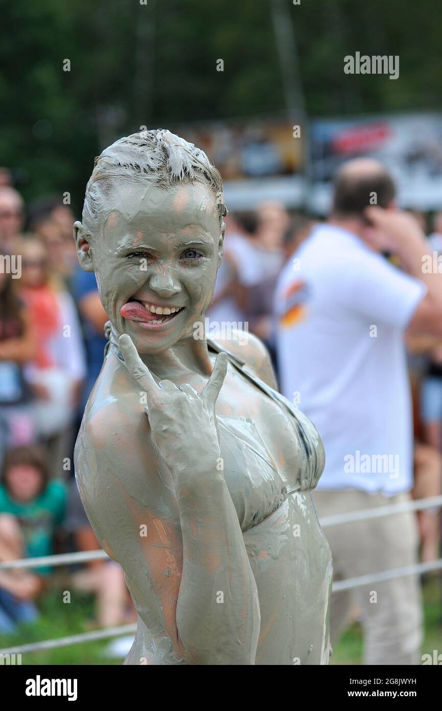 Mud girl claims victory in the ring, crowd of people watching. Mud wrestling show. June 23, 2017. Kiev, Ukraine Stock Photo