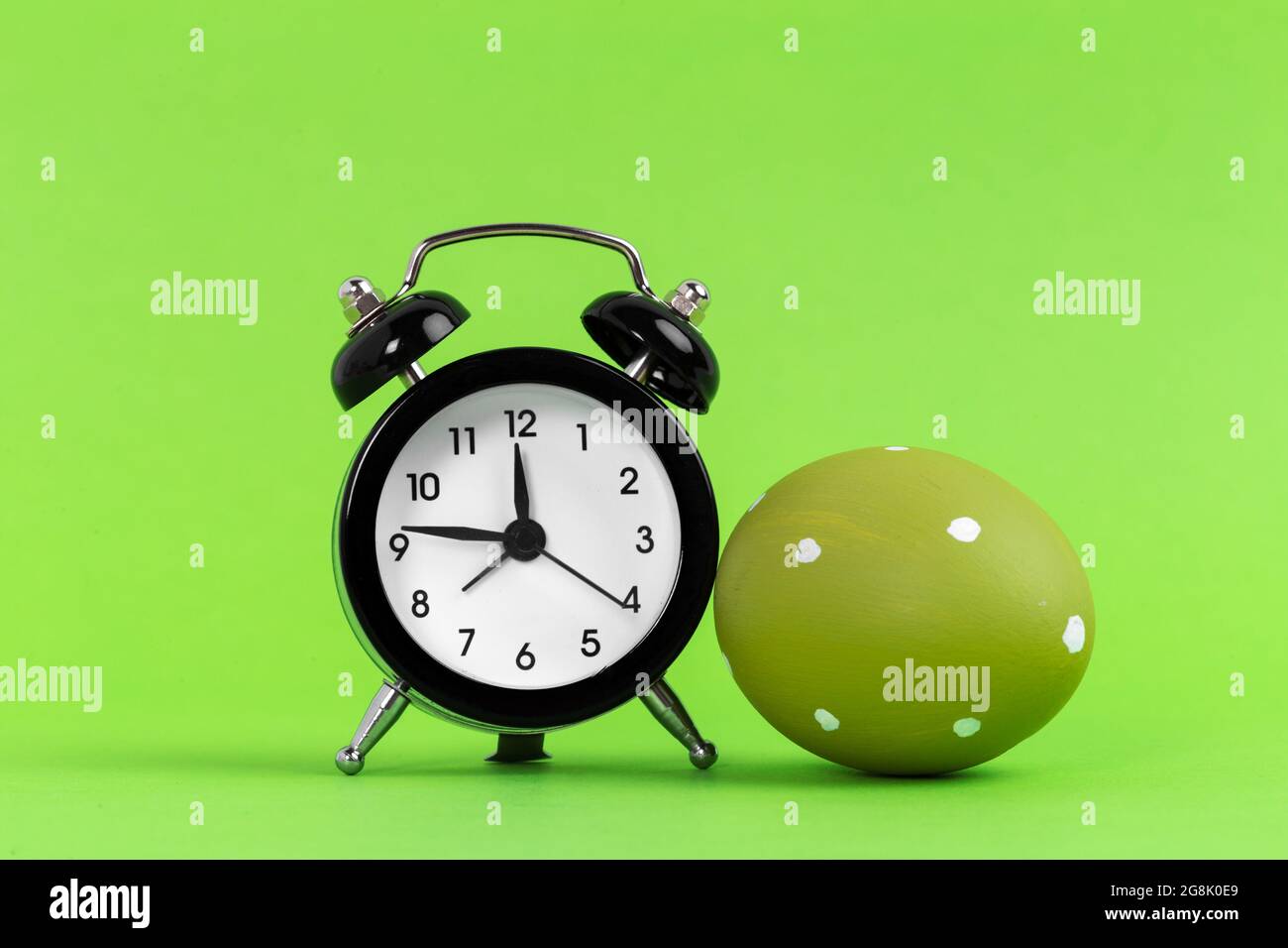 Easter alarm clock with colorful egg. Time to celebrate Stock Photo Alamy
