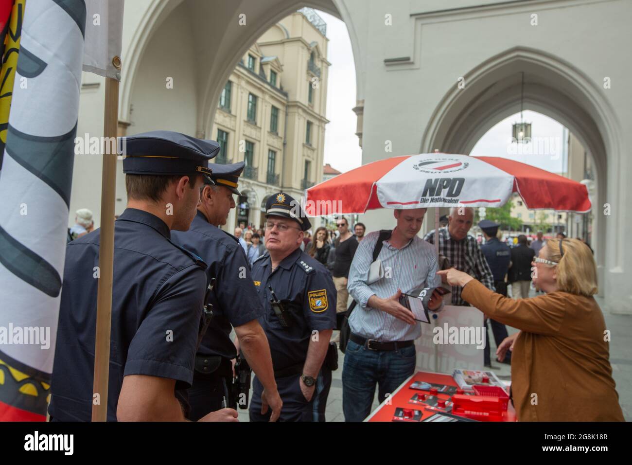 Munich, Germany. 25th May, 2019. Renate Wehrlberger discussing with police on a flyer reading ' Migration kills '. The supreme court judged it's not illegal. The neonazi party NPD had a stand in Munich for the upcoming European Elections. (Photo by Alexander Pohl/Sipa USA) Credit: Sipa USA/Alamy Live News Stock Photo