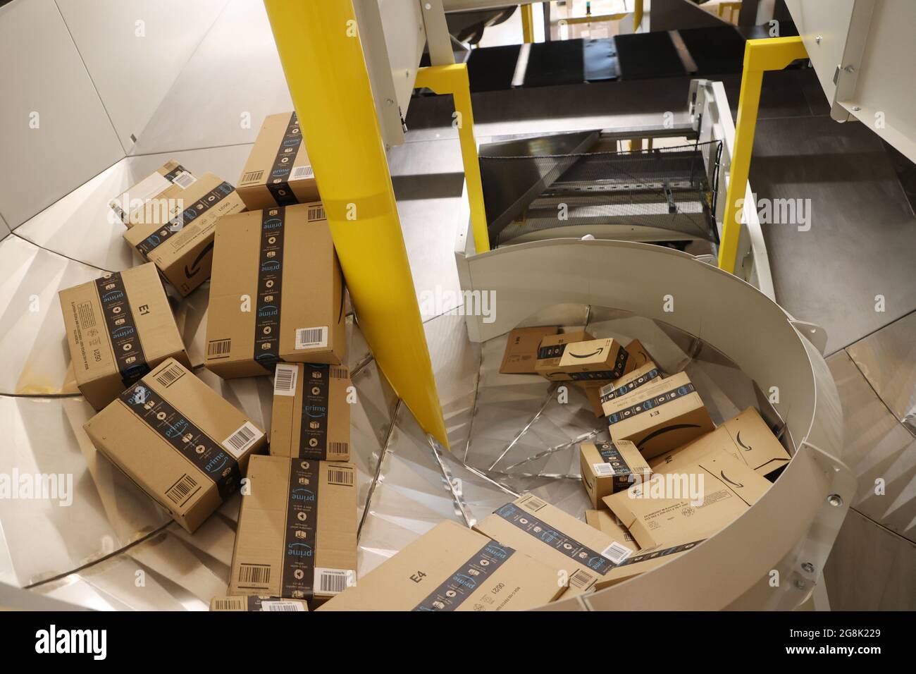 Gera, Germany. 21st July, 2021. Amazon shipping boxes lie on conveyor belts  during a trial run in a logistics hall. In Gera, the online mail order  company Amazon is building a large