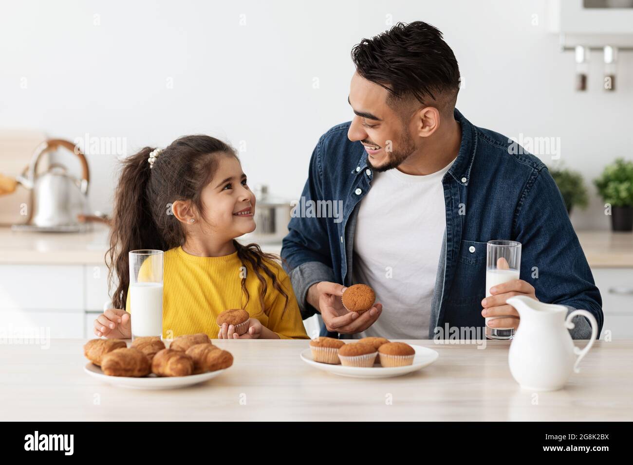 Little Arab Girl And Daddy Having A Bite In Kitchen At Home Stock Photo