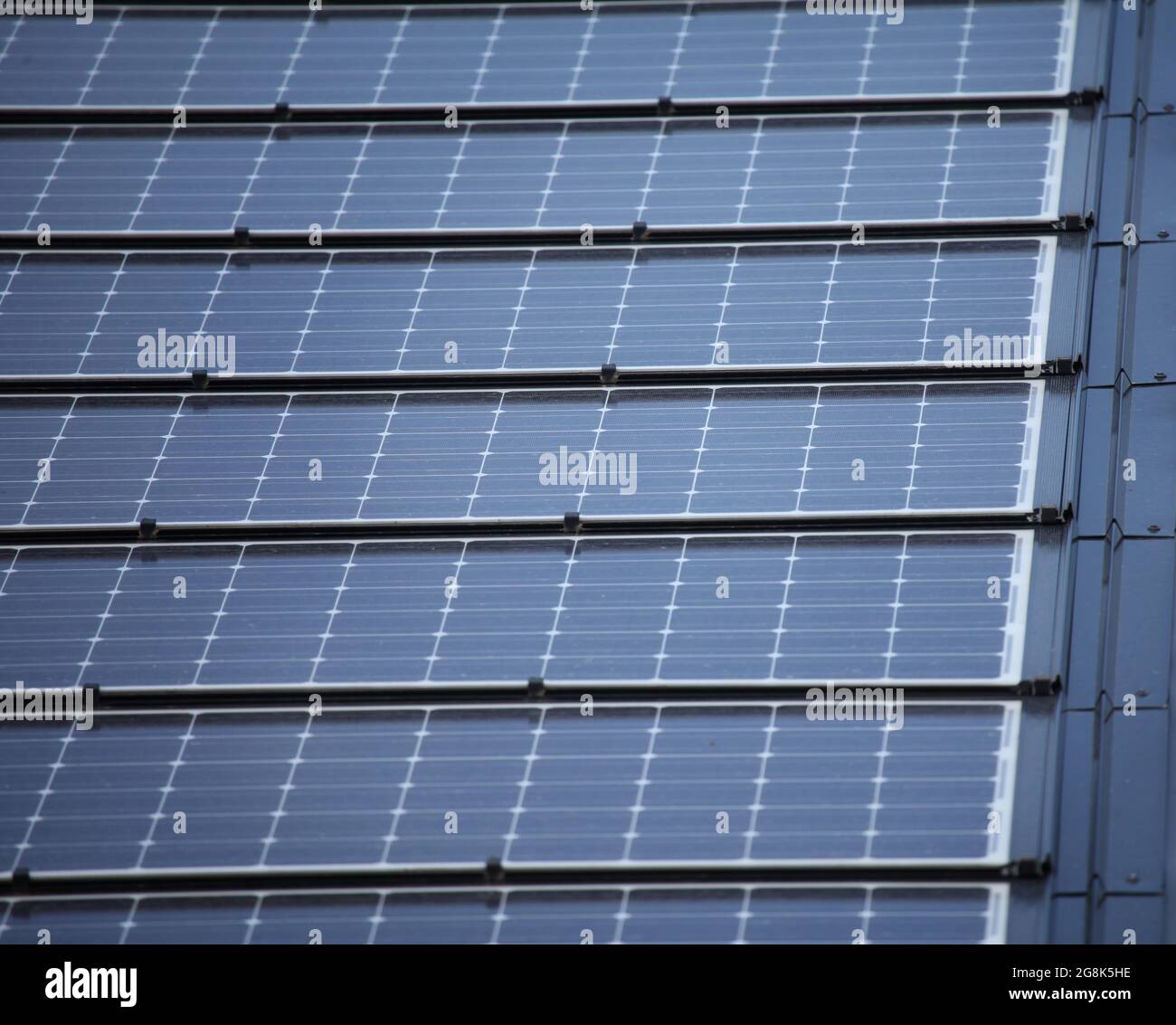 Rows of blue solar panels on a roof under a bright sky Stock Photo - Alamy