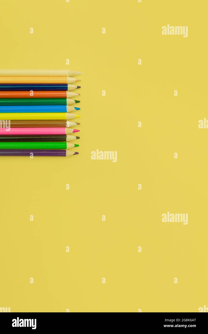 colored pencils on a yellow background Stock Photo - Alamy