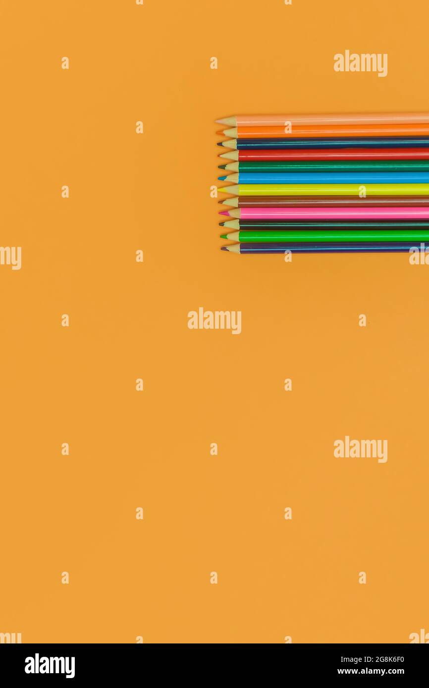 colored pencils on a yellow background Stock Photo