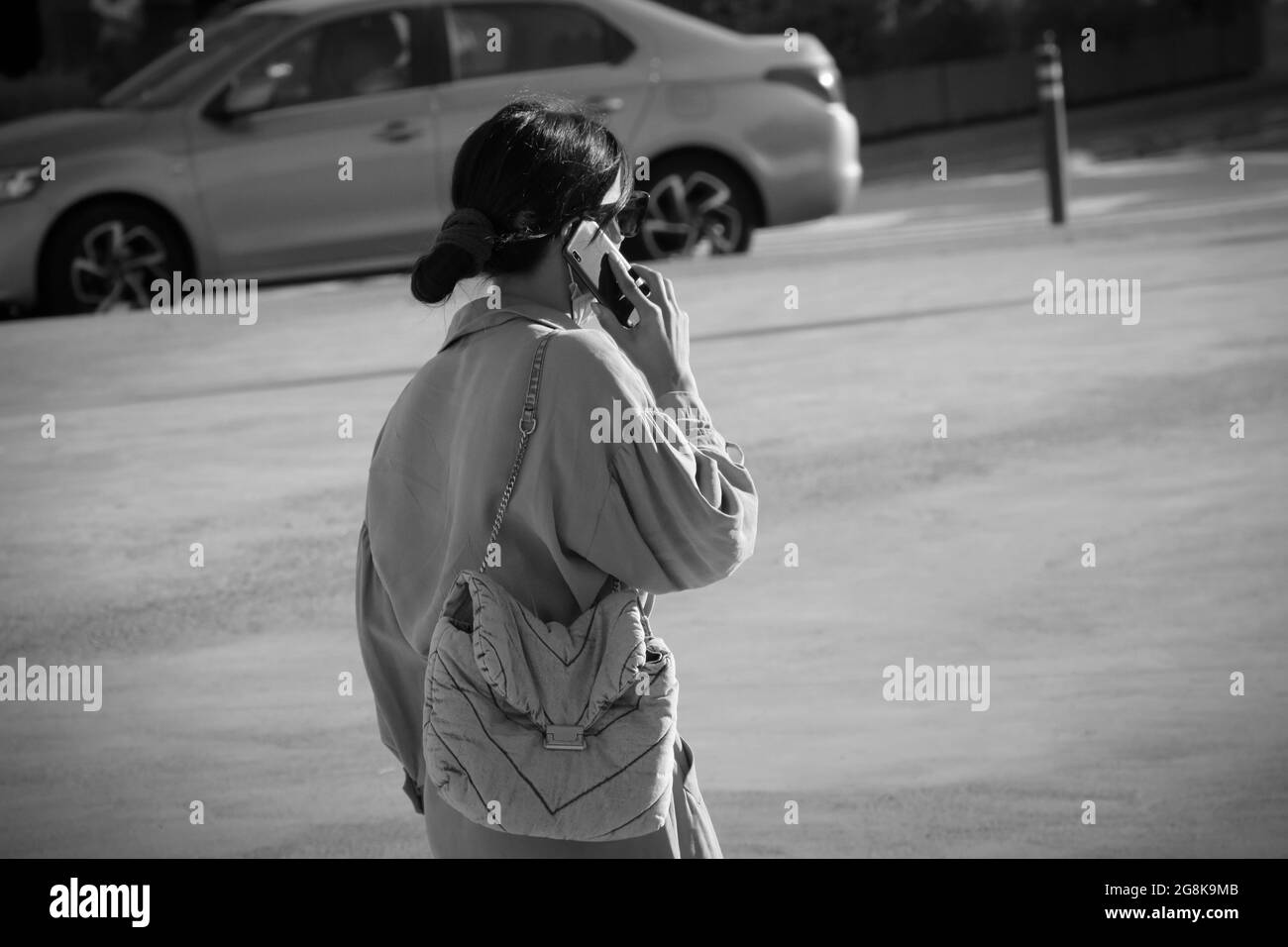 Woman is talking by mobile phone in a street. Stock Photo