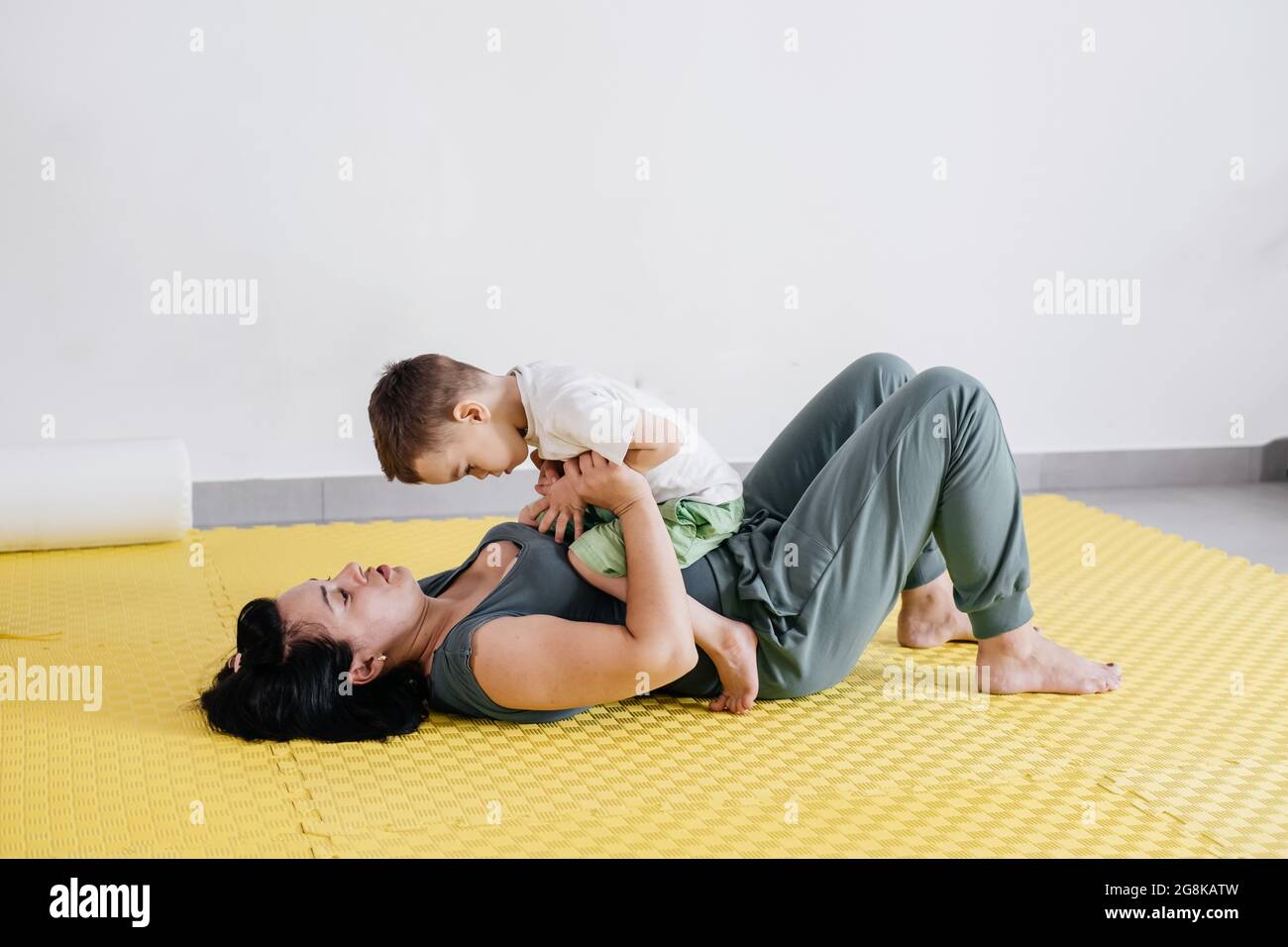 Rehabilitation of child with cerebral palsy in special center. Mother doing physical exercises and happily playing with boy, Sport activities for Stock Photo