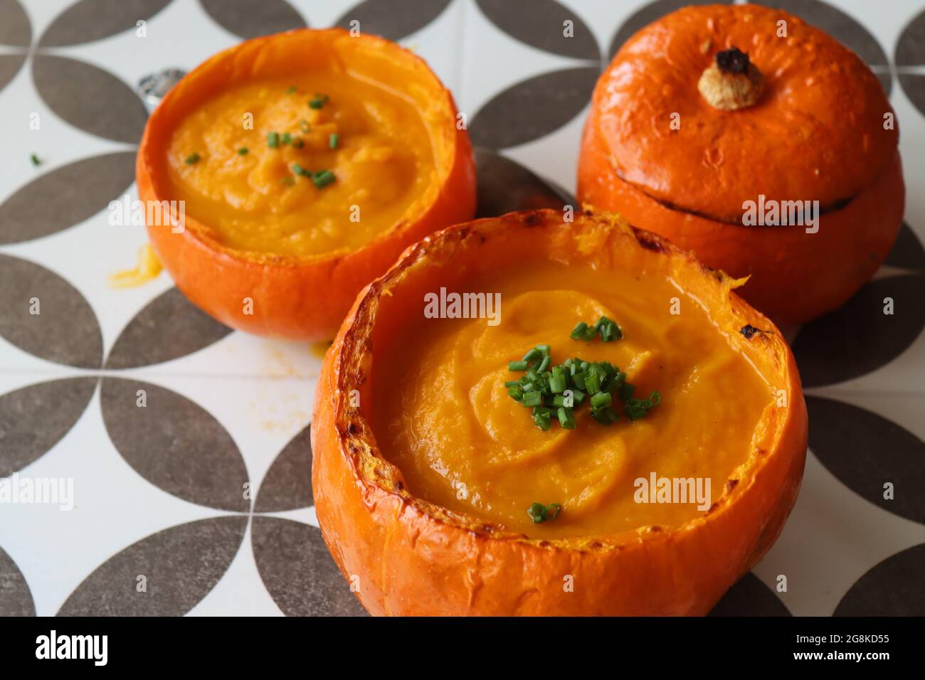 Curried butternut squash soup with coconut milk. Vegan pumpkin soup served in a squash shell. Eating healthy concept. Stock Photo