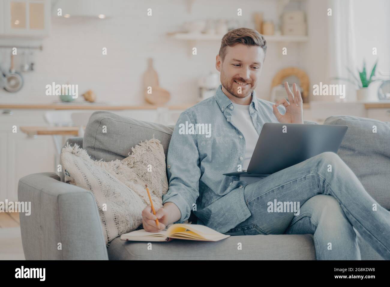 Young freelancer taking orders from client and writing them down Stock Photo
