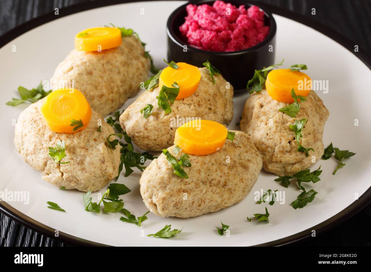 Gefilte Fish Boiled fishballs served with horseradish and carrots close-up in a plate on the table. horizontal Stock Photo