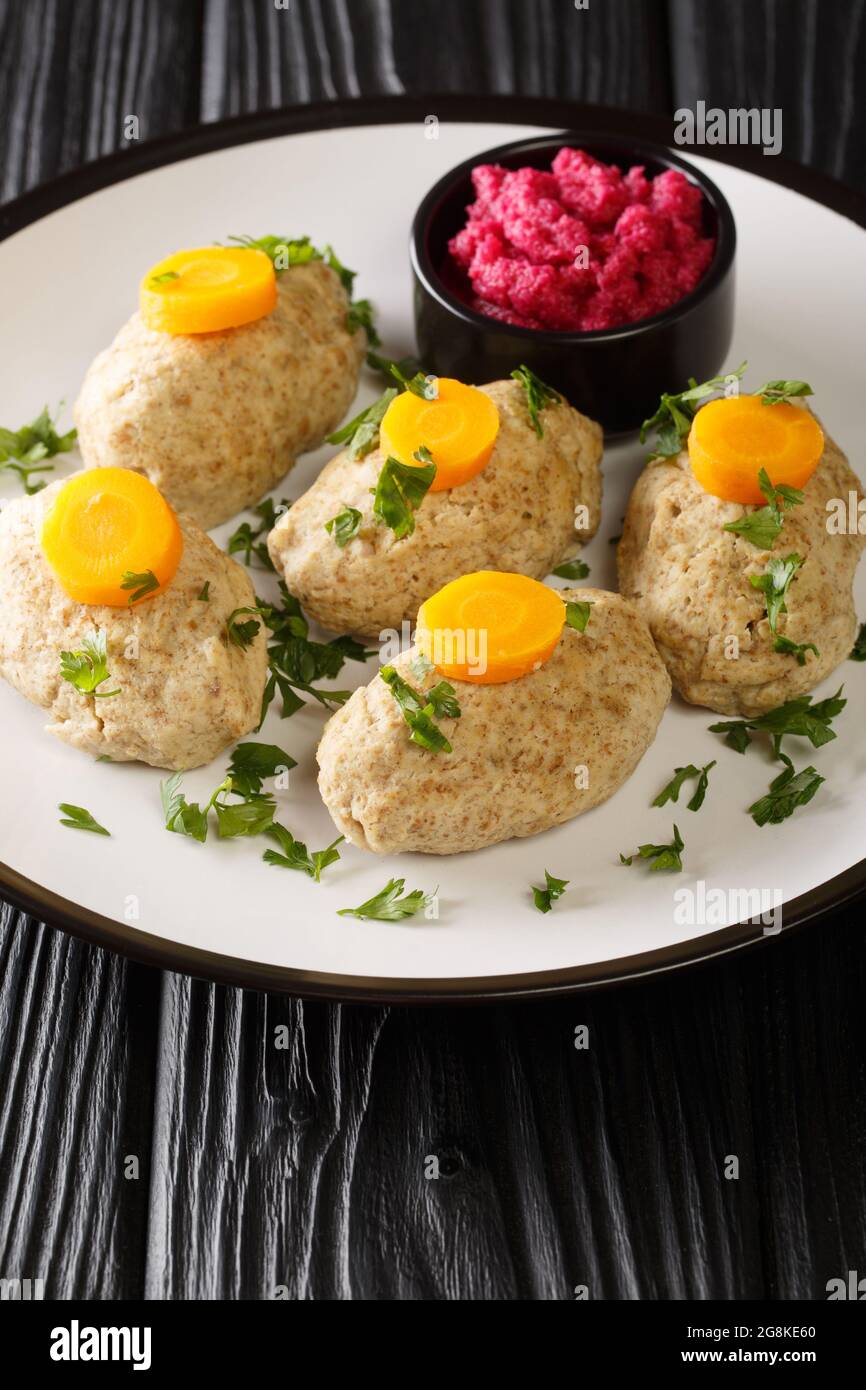 Jewish Gefilte Fish Recipe with Beet Horseradish closeup in the plate on the tble. Vertical Stock Photo