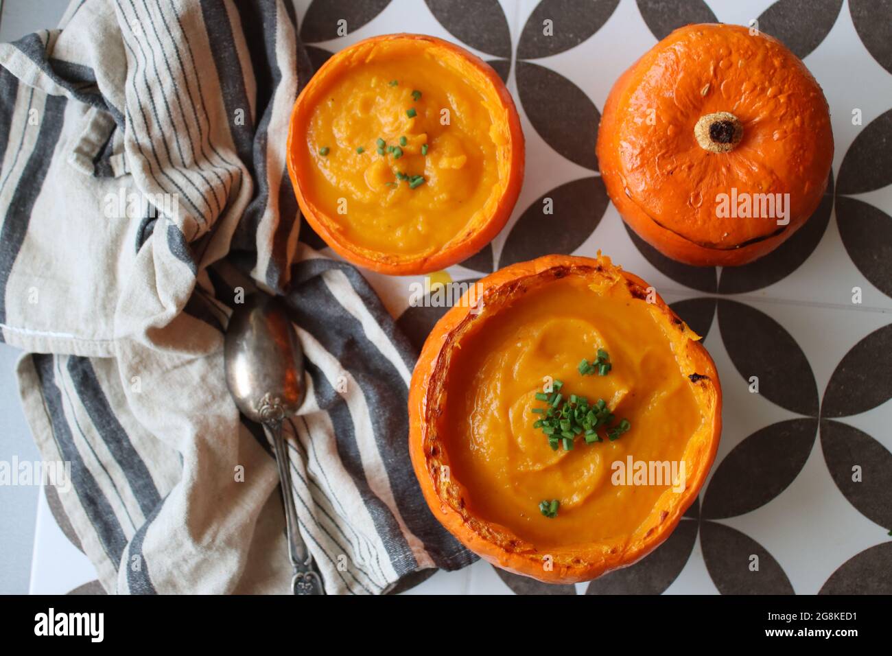 Curried butternut squash soup with coconut milk. Vegan pumpkin soup served in a squash shell. Eating healthy concept. Stock Photo