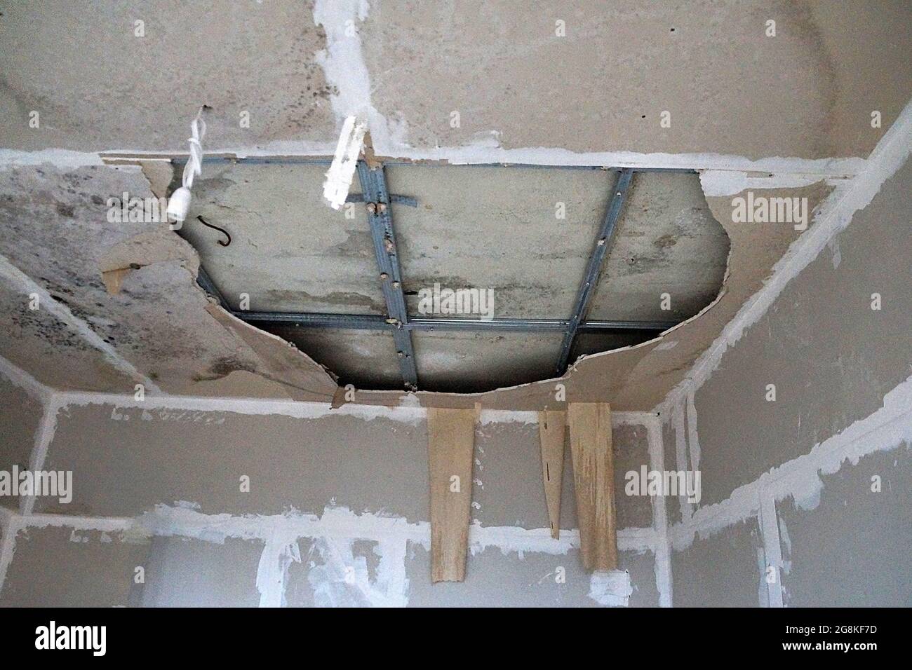 collapsed plasterboard ceiling rotted due to dampness close-up Stock Photo