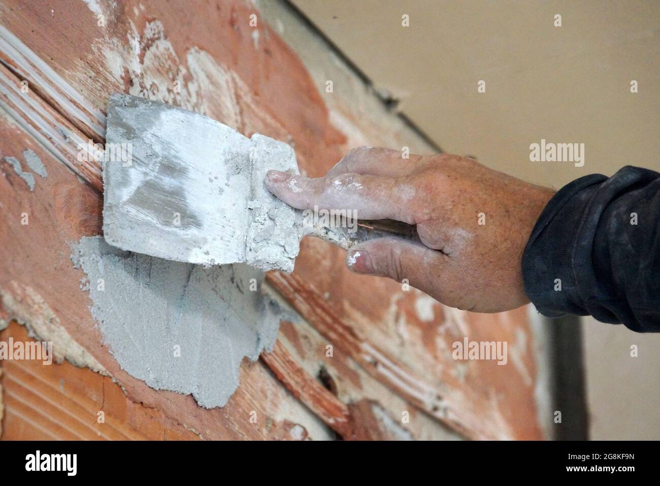 male hand with trowel plastering brick wall close-up Stock Photo