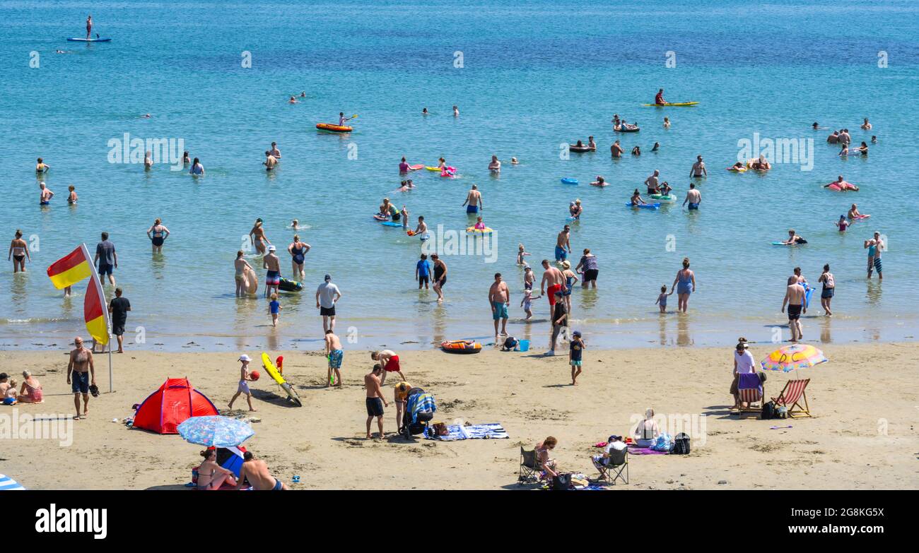 Lyme Regis, Dorset, UK. 21st July, 2021. UK Weather: Crowds of beachgoers packed out the picturesque beach at the seaside resort of Lyme Regis as temperatures soared towards 30 degrees centigrade again this afternoon. Holiday makers and beachgoers sweltered in record breaking temperatures as the Met Office extended the amber warning of 'Extreme Heat' as the heatwave continues to the end of the week. Credit: Celia McMahon/Alamy Live News Stock Photo